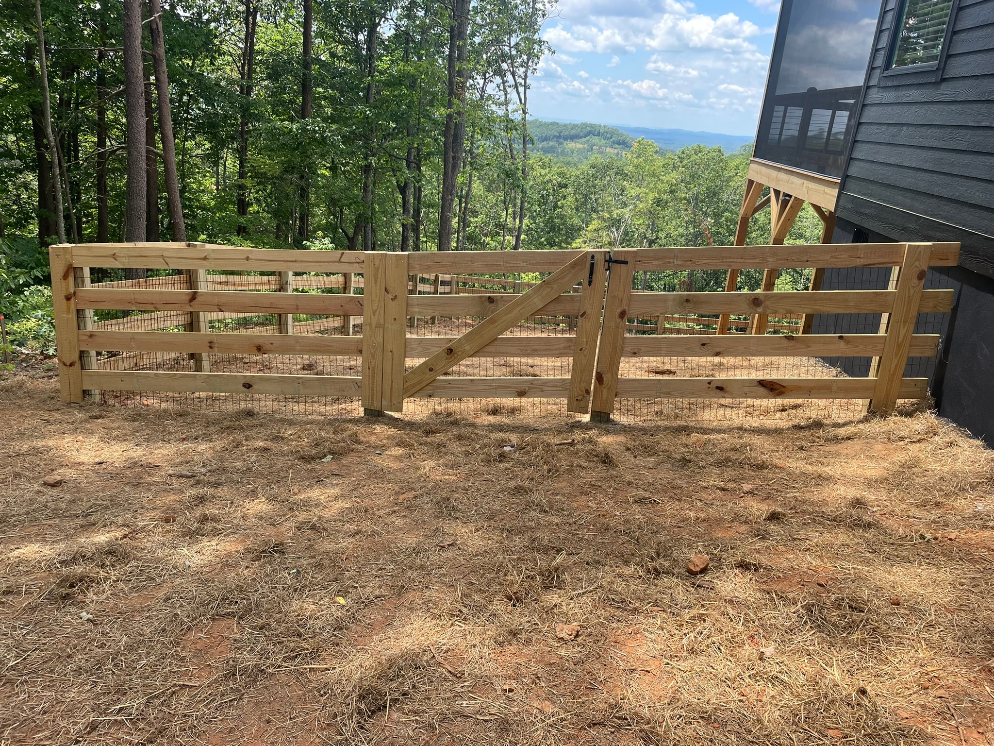 Wooden farm gates with mountain forest view